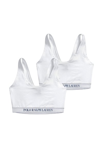 Deux brassières de sport blanches avec des bretelles larges et des bandes élastiques portant le texte "POLO RALPH LAUREN" en bleu marine sur fond blanc.