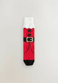 Chaussette rouge avec un design de costume de Noël, dotée d'un poignet en fourrure blanche, d'une ceinture noire et d'une boucle dorée à l'avant ; texture lisse.