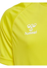 Camiseta deportiva de color amarillo brillante hecha de un tejido suave y ligero. Presenta un logo blanco en el pecho y un diseño de manga corta.