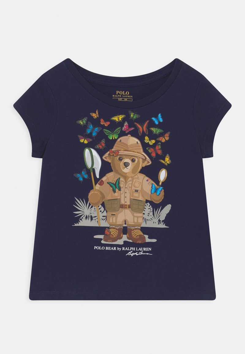 Tmavě modré tričko s kresleným medvědem v safari outfitu, obklopeným barevnými motýly. Krátké rukávy a kulatý výstřih.