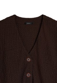 Brązowy sweter z fakturowanej dzianiny, o dekolcie w serek, z pięcioma dużymi guzikami w ciemnym brązie i pomarańczowymi akcentami, wykonany z miękkiego, tkanej tkaniny.