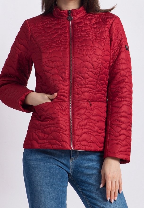 Veste matelassée rouge avec un col montant, fermeture éclair sur toute la longueur et un motif texturé. Elle possède des poches latérales et un design ajusté.