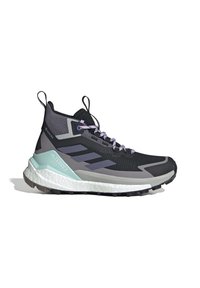 Chaussure de trail montante noire et grise avec semelle blanche et menthe, lacets violets, languettes et semelle texturée sur fond blanc.
