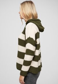 Hanorac tricotat în dungi, de culoare verde măsliniu și crem, cu un design texturat din croșetă, dotat cu glugă și croială relaxată.