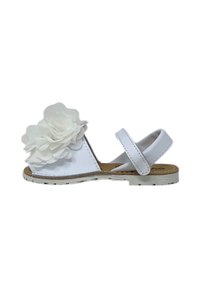 Sandal bianca con due fasce regolabili, caratterizzata da un grande fiore bianco sulla zona delle dita. Suola piatta e semplice dettaglio di cucitura.
