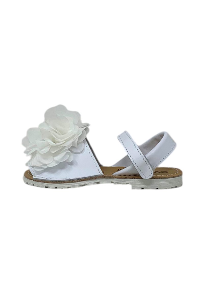 Sandal bianca con due fasce regolabili, caratterizzata da un grande fiore bianco sulla zona delle dita. Suola piatta e semplice dettaglio di cucitura.