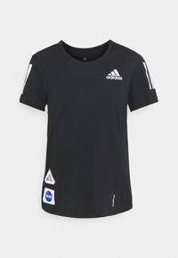 Černé tričko s krátkým rukávem vyrobené z bavlny, s bílým logem Adidas na hrudi, třemi bílými pruhy na rukávu a NASA nášivkami.