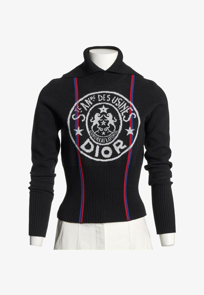 Pull côtelé noir à manches longues avec col montant, rayures verticales rouges et bleues, et logo Dior circulaire blanc sur le devant.