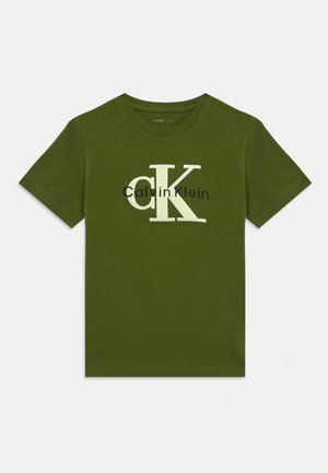 Olíva zöld rövid ujjú póló nagy fehér "cK" és fekete "Calvin Klein" logóval, középre helyezve a mellkason.
