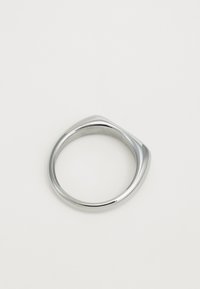 Smooth silver ring with a slightly irregular, rounded shape, photographed on a plain light background.