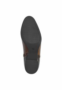 Chaussure en cuir marron avec une semelle en caoutchouc noir texturé. Présente une finition lisse et un design embossé sur la partie supérieure. Taille marquée comme 37.