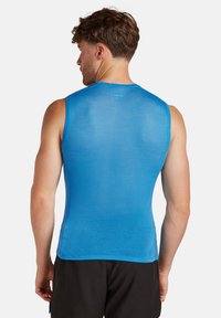 Blaues ärmelloses Sportoberteil aus strukturiertem Mesh-Gewebe, mit einem runden Ausschnitt und einer figurbetonten Passform, geeignet für Sportbekleidung.