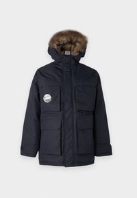 Marinblå parkasjacka med pälsfodrad huva, flera frampocket och en dekorerande patch. Tillverkad av vattentåligt material.