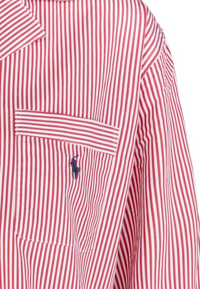 Červeno-bíle pruhované tričko s kapsou, zdobené vyšitým logem. Měkká látka, volný střih, klasický límec.