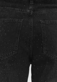 Czarne dżinsy z denimu z wzorem w ćwieki, dwiema tylnymi kieszeniami oraz klasycznym pięciokieszonkowym designem z delikatnym teksturowanym wykończeniem.