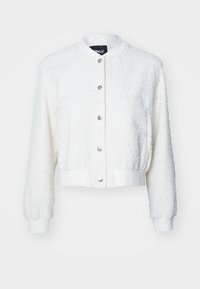 White bomber jacket with a textured fabric, ribbed cuffs, and hem. Features silver snap buttons and a round collar.