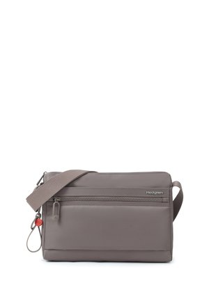 Petit sac bandoulière gris compact avec poche zippée à l'avant, bandoulière réglable et petit pendentif rouge sur anneau métallique.