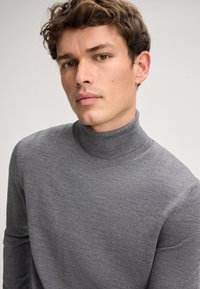 Gray turtleneck sweater made of soft fabric, fitted design, long sleeves, seamless neckline, subtle texture with a smooth finish.
