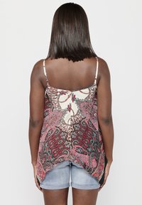 Débardeur à motifs avec un mélange de couleurs rouge, noir et crème ; tissu léger ; design fluide ; ourlet en forme de vagues ; bretelles spaghetti.