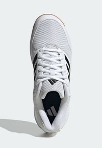 Zapatilla deportiva blanca con parte superior de malla, rayas negras y cordones blancos. Presenta una suela acolchada y un logotipo en el interior de la zapatilla. Diseño plano.