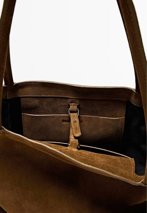 Borsa a tracolla in suede marrone con un ampio interno, dotata di un clasp in pelle e due tasche interne. Morbida al tatto e con manici robusti.