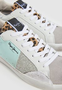 Sneaker bianche con dettagli in verde menta e grigio, particolare in metallo argento e tessuto a stampa leopardata sulla linguetta. Presentano lacci bianchi.