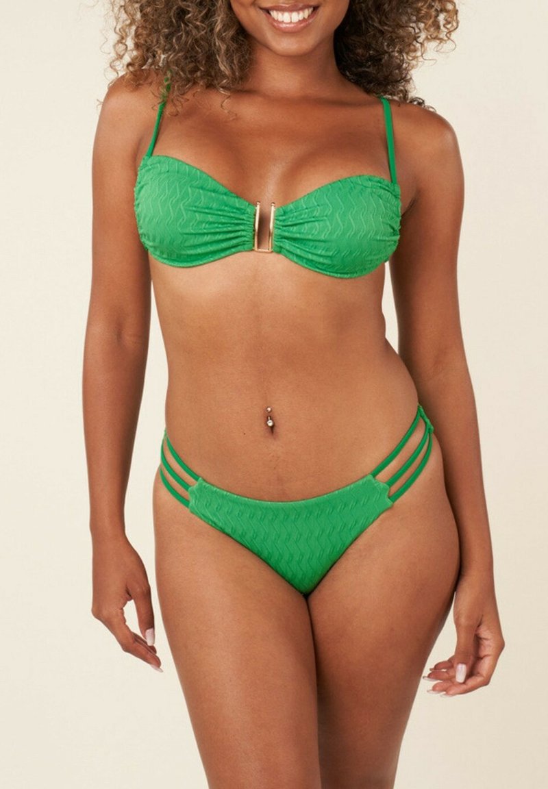 Bikini vert avec un haut bandeau froncé et un accent doré, accompagné de bas assortis avec des lanières sur les côtés. Motif texturé sur l'ensemble.