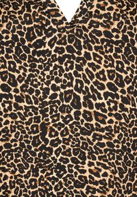 Tkanina s leopardím vzorom má hnedasté pozadie s čiernymi a hnedými škvrnami. Textúra sa zdá byť hladká, vhodná na rôzne oděvy.