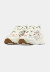 Paire de baskets compensées blanches avec motifs floraux, lacets à l'avant et semelles en caoutchouc marron sur fond blanc uni.