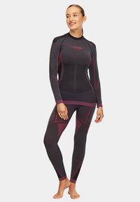 Czarny top kompresyjny i legginsy z różowymi akcentami. Teksturowana tkanina z ergonomiczną konstrukcją, długie rękawy i bezszwowe wykończenie.