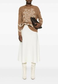 Maglione lavorato a maglia marrone e crema con motivo, abbinato a una gonna a campana bianca e stivali al ginocchio color crema, con una pochette nera testurizzata.