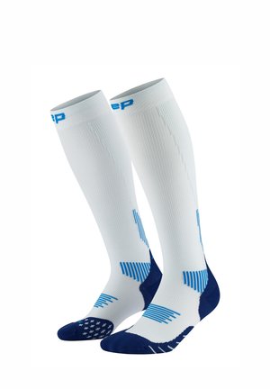 Knee-high socks with a white body, blue accents, textured and striped patterns, and cushioned navy blue toe and heel sections.