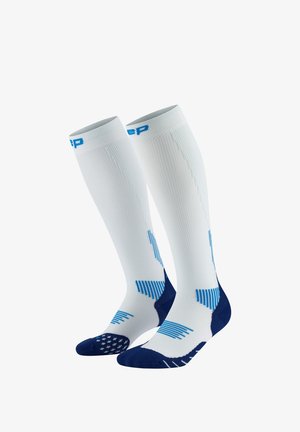 Knee-high socks with a white body, blue accents, textured and striped patterns, and cushioned navy blue toe and heel sections.