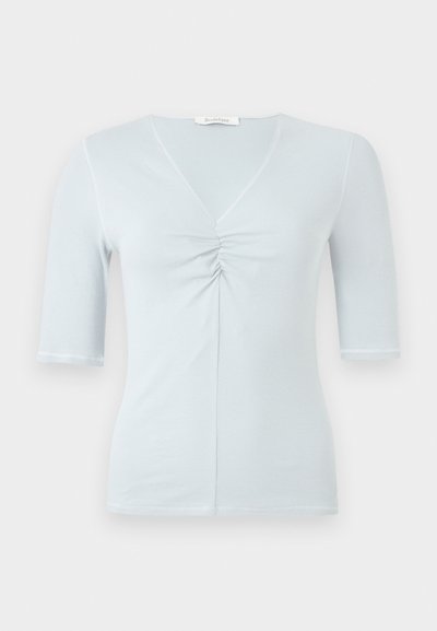 Ανοιχτό μπλε ριμπ μπλουζάκι με κοντά μανίκια, V λαιμόκοψη και συγκεντρωμένη λεπτομέρεια στο κέντρο μπροστά, εμφανίζεται σε απλό λευκό φόντο.