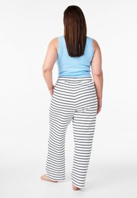Top de tirantes acanalado azul claro con encaje, combinado con pantalones de pierna ancha a rayas blancas. Cintura elástica visible y una tela texturizada.