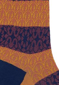 Calze lavorate a maglia con un motivo geometrico che presenta sezioni gialle, borgogna e blu navy; variazioni di texture creano un interesse visivo.