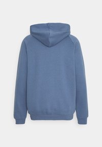 Blå huvtröja med ribbad textur, känguruficka och åtsittande muddar. Slät tyg med inga synliga mönster eller detaljer.