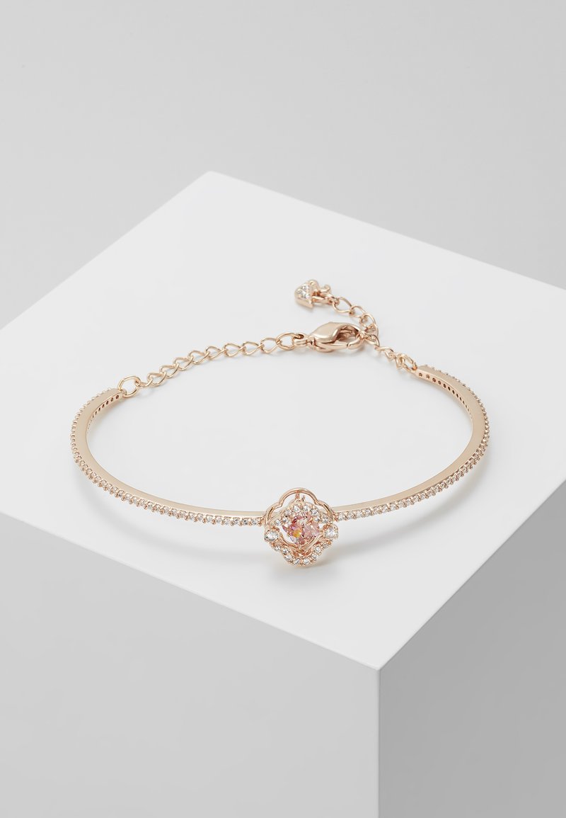 Bracciale in oro rosa con un centro floreale decorato da pietre iridescenti, arricchito da piccoli cristalli trasparenti lungo la fascia.