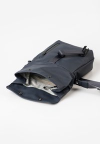 Navyblaue Umhängetasche mit vorderer Reißverschlusstasche, verstellbarem Trageriemen und offenem Hauptfach, das eine beigefarbene Innentasche mit Reißverschluss zeigt.
