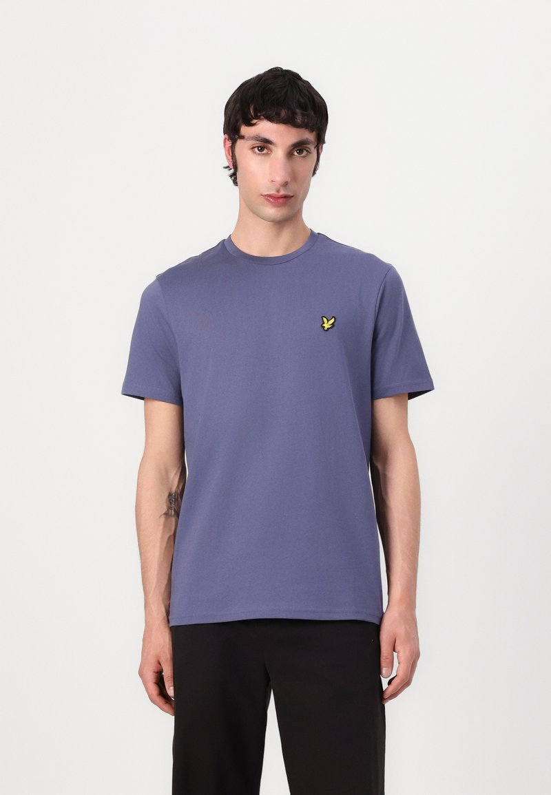 Purple cotton t-shirt with short sleeves and a crew neckline, featuring a small yellow butterfly logo on the left chest.