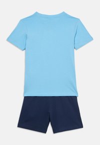 Ανοιχτό μπλε κοντομάνικο μπλουζάκι με στρογγυλή λαιμόκοψη, συνοδευόμενο από σκούρο μπλε σορτς, και τα δύο από απαλό βαμβακερό ύφασμα.