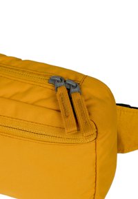 Borsa di stoffa gialla di forma rettangolare, con elementi in zip grigia e superficie testurizzata. Include una cerniera visibile e dettagli imbottiti.