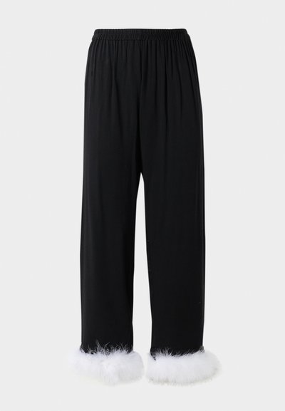 Črne hlače iz mehkega materiala, z širokim elastičnim pasom in belimi umetnimi krznom na robu. Ravne noge.