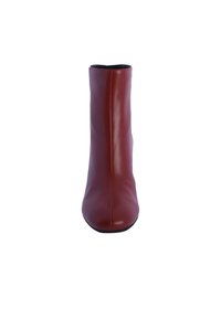 Botín de piel roja hasta el tobillo con una silueta elegante, punta ligeramente afilada y sin herrajes visibles. Textura suave y diseño minimalista.
