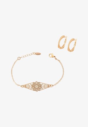 Gold-tone bracelet with floral filigree centerpiece and matching textured hoop earrings on a white background.