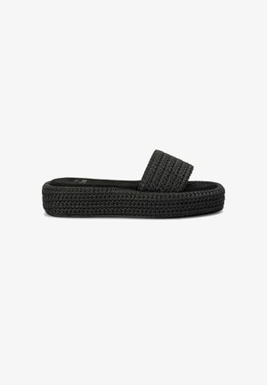 Zwarte gevlochten slip-on sandaal met een dikke, gestructureerde band en een platformzool, met een glad voetbed en een ribbelpatroon op de bovenste band.