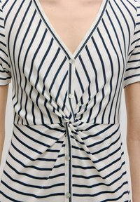 Gestreepte gebreide jurk met een marineblauw en witte kleurenschema, V-hals, korte mouwen en een twist-detail bij de taille met knoopsluiting.