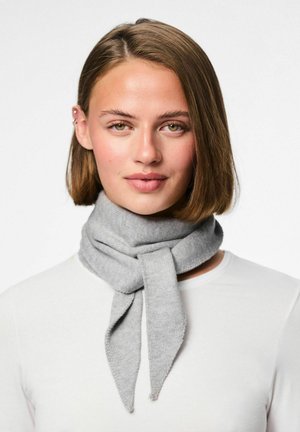 Une écharpe tricotée grise en matériau doux, enroulée autour du cou avec des extrémités pointues, complétant une chemise blanche portée en dessous.