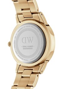 Reloj de acero inoxidable dorado con una caja redonda pulida, una parte trasera lisa y una correa de eslabones. Presenta el nombre de la marca y el número de serie en la parte trasera.