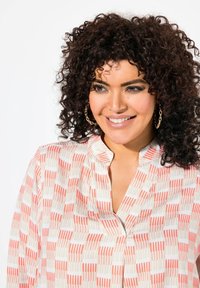 Blusa in tessuto leggero con un motivo a righe alternate in corallo e beige, dotata di colletto alla mandarino e taglio verticale.